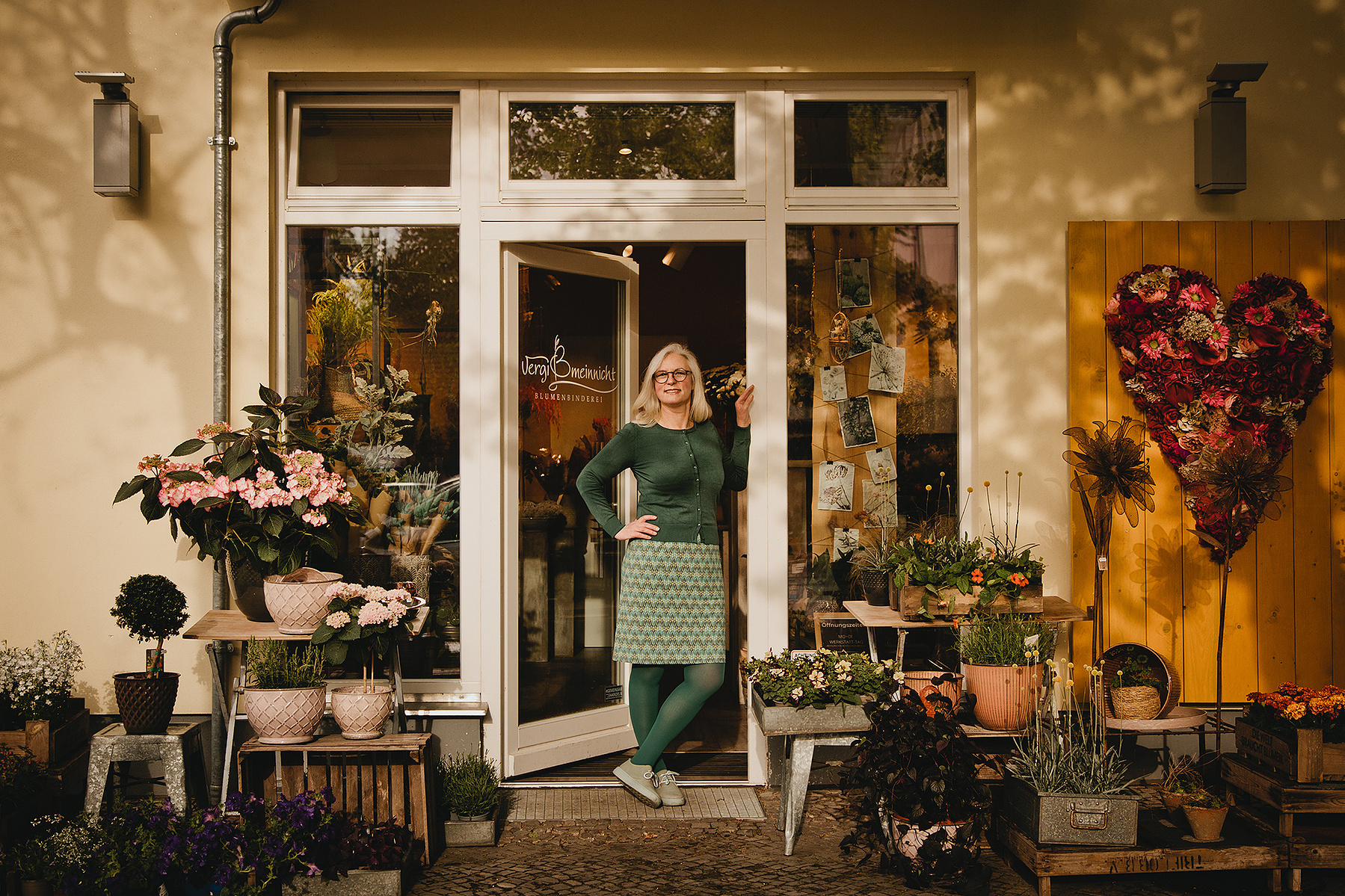 Eine Floristin posiert für natürliche Businessfotos in Berlin vor ihrem Blumenladen. 