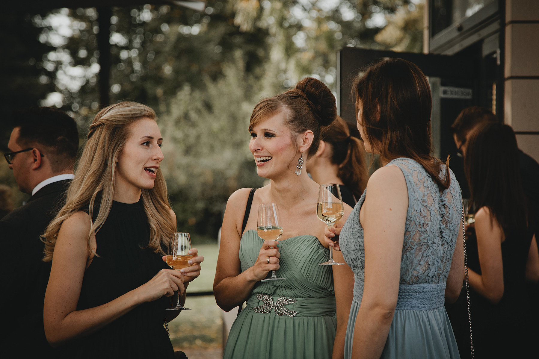 Hochzeitsgäste amüsieren sich beim Sektempfang einer lockeren Hochzeit im Grünen in Köpenick.
