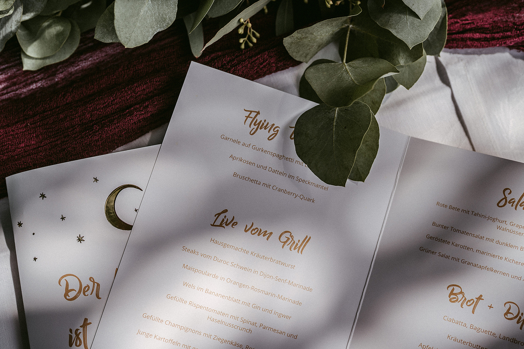 Papeterie für eine Celestial Wedding im Bohostil. Die Menükarten liegen auf einem Tisch mit Eukalyptus.