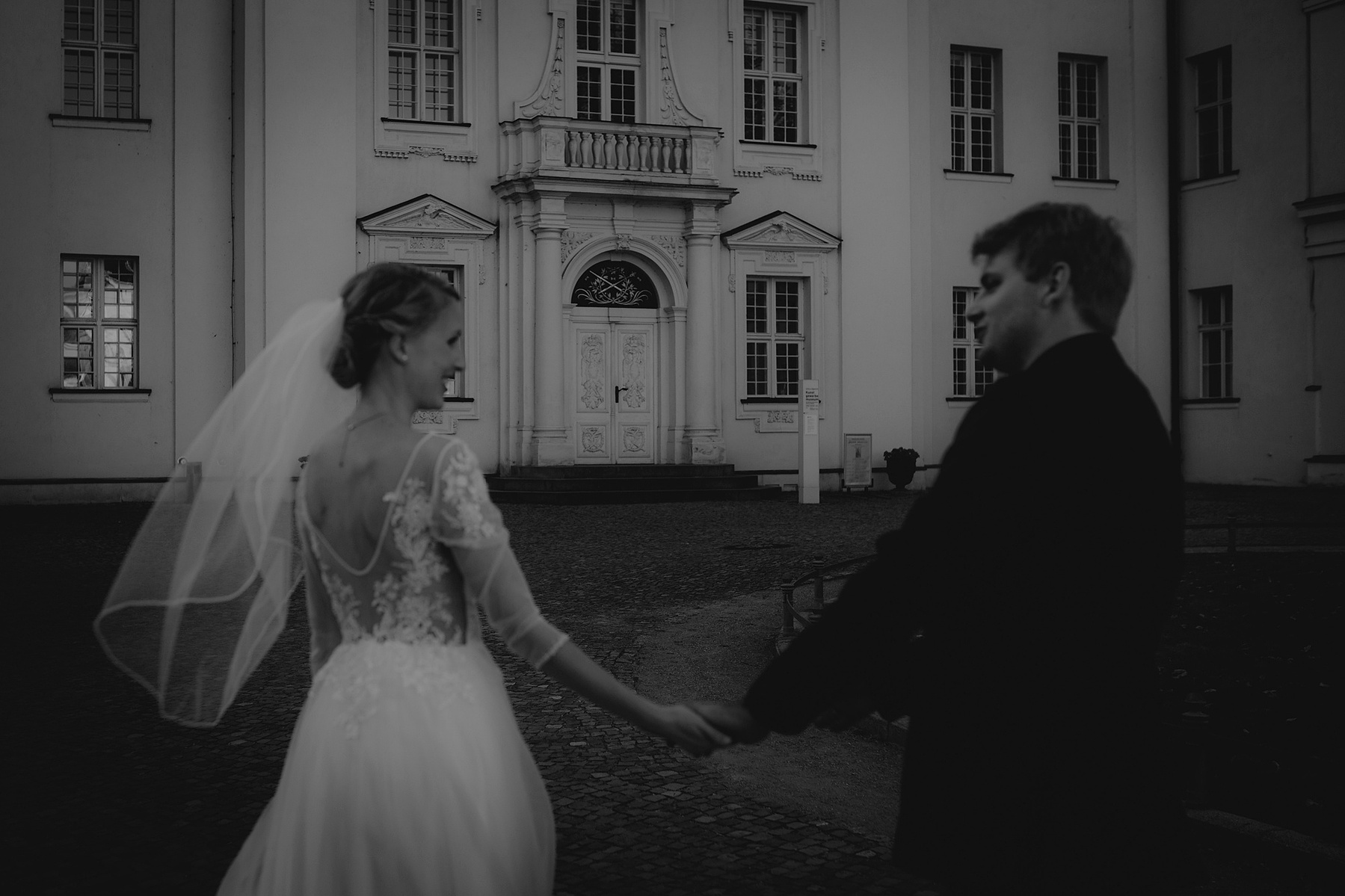 Atmosphärische Momentaufnahme eines Brautpaars vor dem Schloss Köpenick.