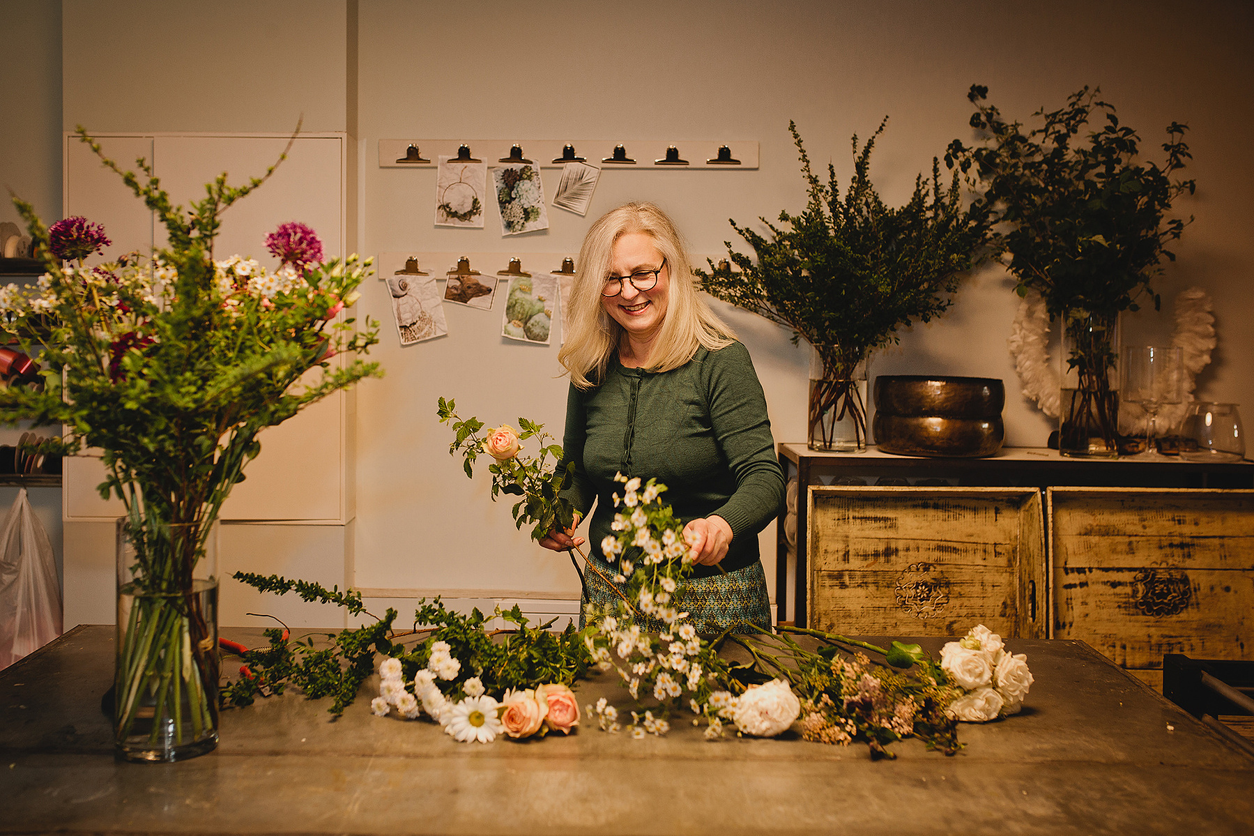 Eine Floristin bindet während eines ungestellten Business Fotoshootings einen Blumenstrauß in ihrer Berliner Werkstatt. 