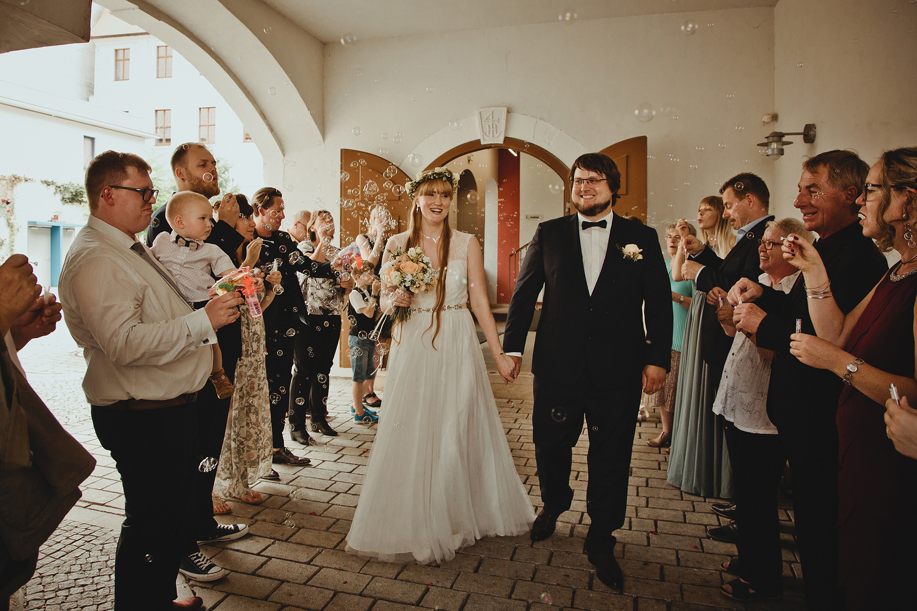 Hochzeitsgäste stehen beim Auszug des Brautpaars vor dem Standesamt Weißenfels Spalier. 