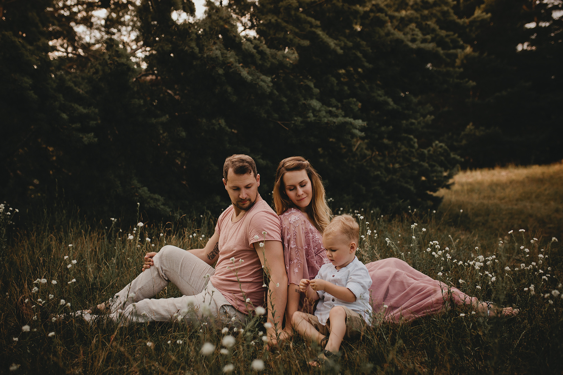 Eine Familie sitzt beim Familienshooting in Brandenburg entspannt auf einer Blumenwiese.