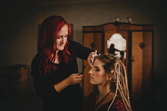 Beim Brautstyling für die Hochzeit werden einer Braut mit Dreadlocks die Haare und das Hake up gemacht.