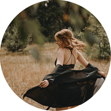 Eine Kundin der Boudoirfotografin aus Berlin lässt beim sinnlichen Fotoshooting in der Natur den Kimono im Wind wehen.