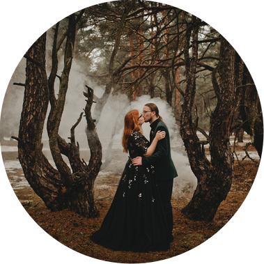Gothic Brautpaar macht Hochzeitsfotos mit Rauchfackeln im Wald im Winter in Brandenburg.