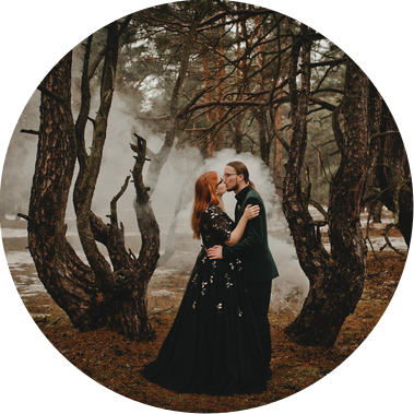 Gothic Brautpaar macht Hochzeitsfotos mit Rauchfackeln im Wald im Winter in Brandenburg