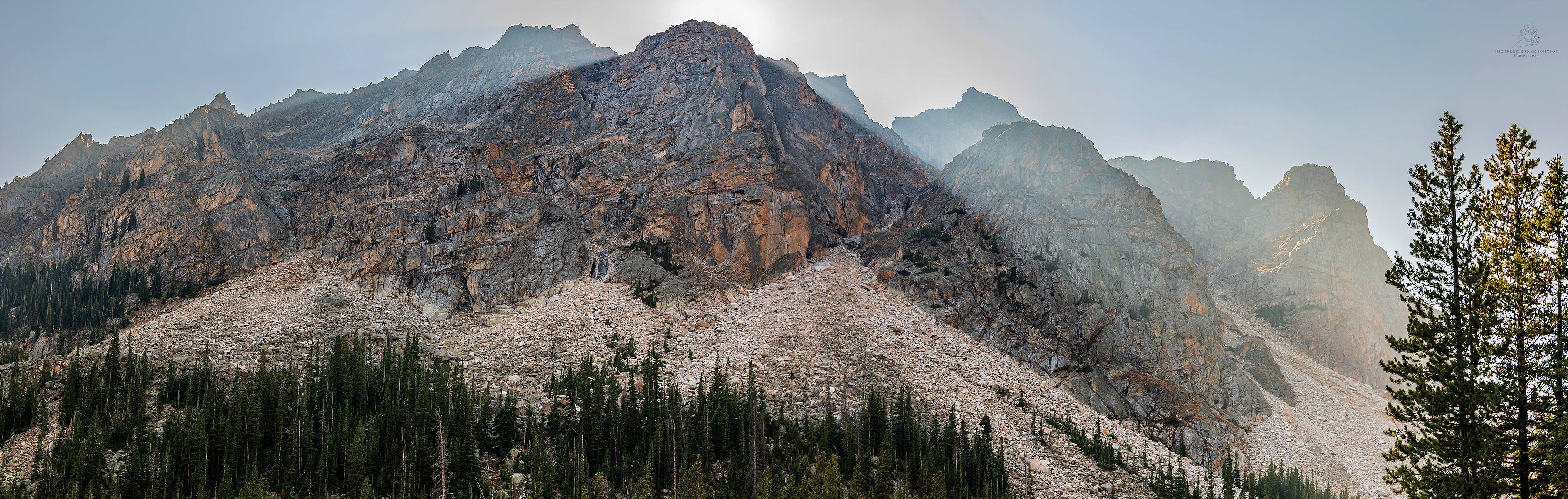 The sun sending light rays behind the amazing mountains above Lost Lake in the Absaroka Beartooth Wilderness, Montana. 