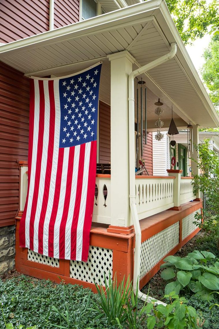 An American flag hanging on a porch of the old house in the historic neighborhood, before the 2020 United States presidential election