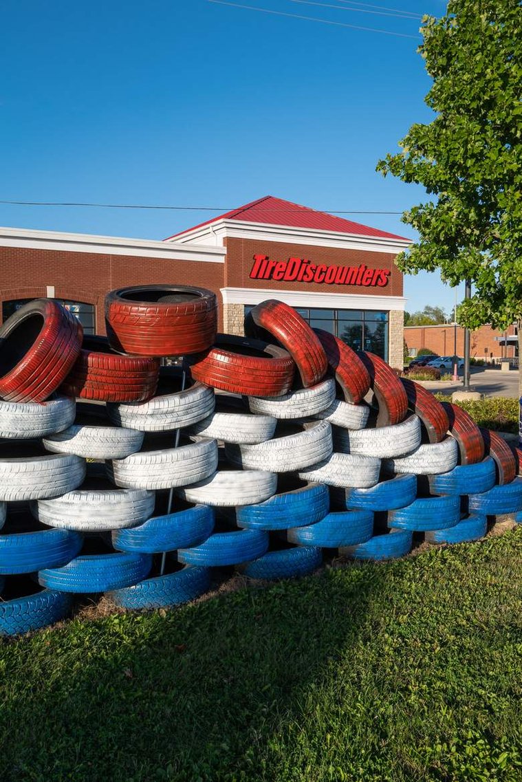 Tires painted in American flag colors stacked in front of Tire Discounters store, before the 2020 United States presidential election