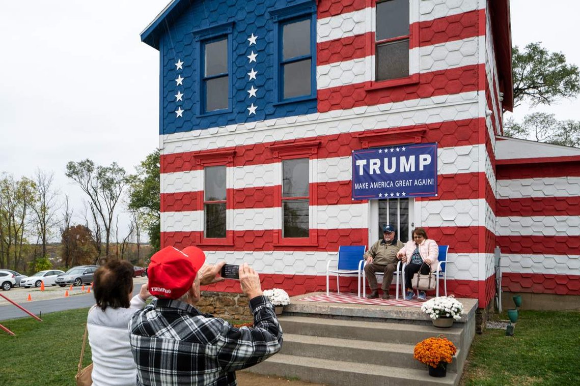 People pose for a photo in front of a house painted in American flag colors in Pennsylvania, before the 2020 United States presidential election