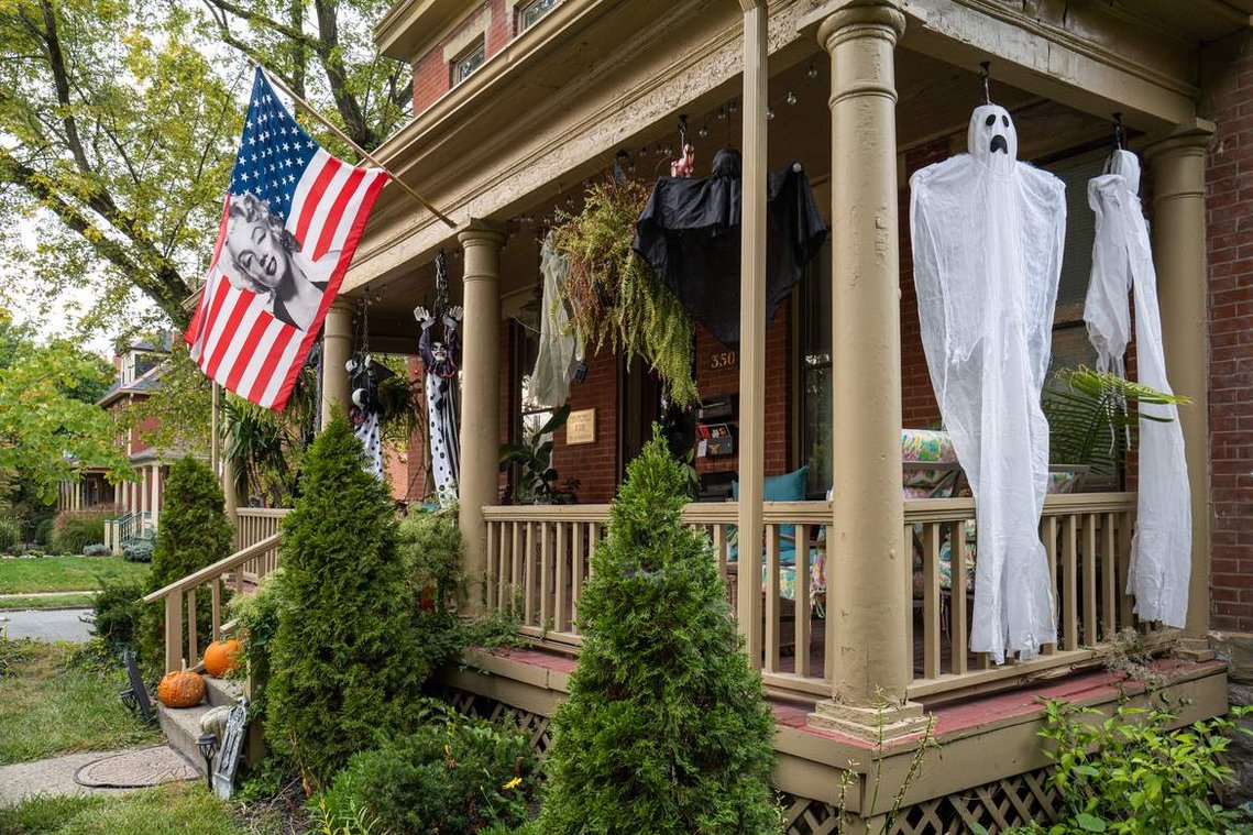An American flag and Halloween decorations hanging on a porch of an old house in the historic neighborhood, before the 2020 United States presidential election