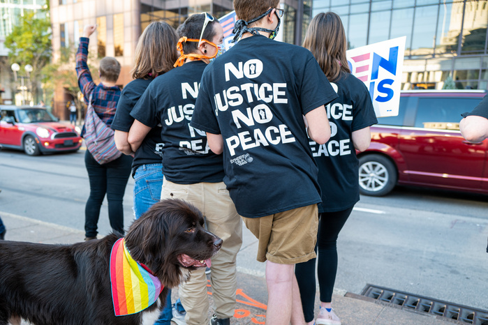 People wearing No Justice No Peace t-shirts and a dog with LGBTQ pride bandana during the celebration of Biden victory in the 2020 United States presidential election