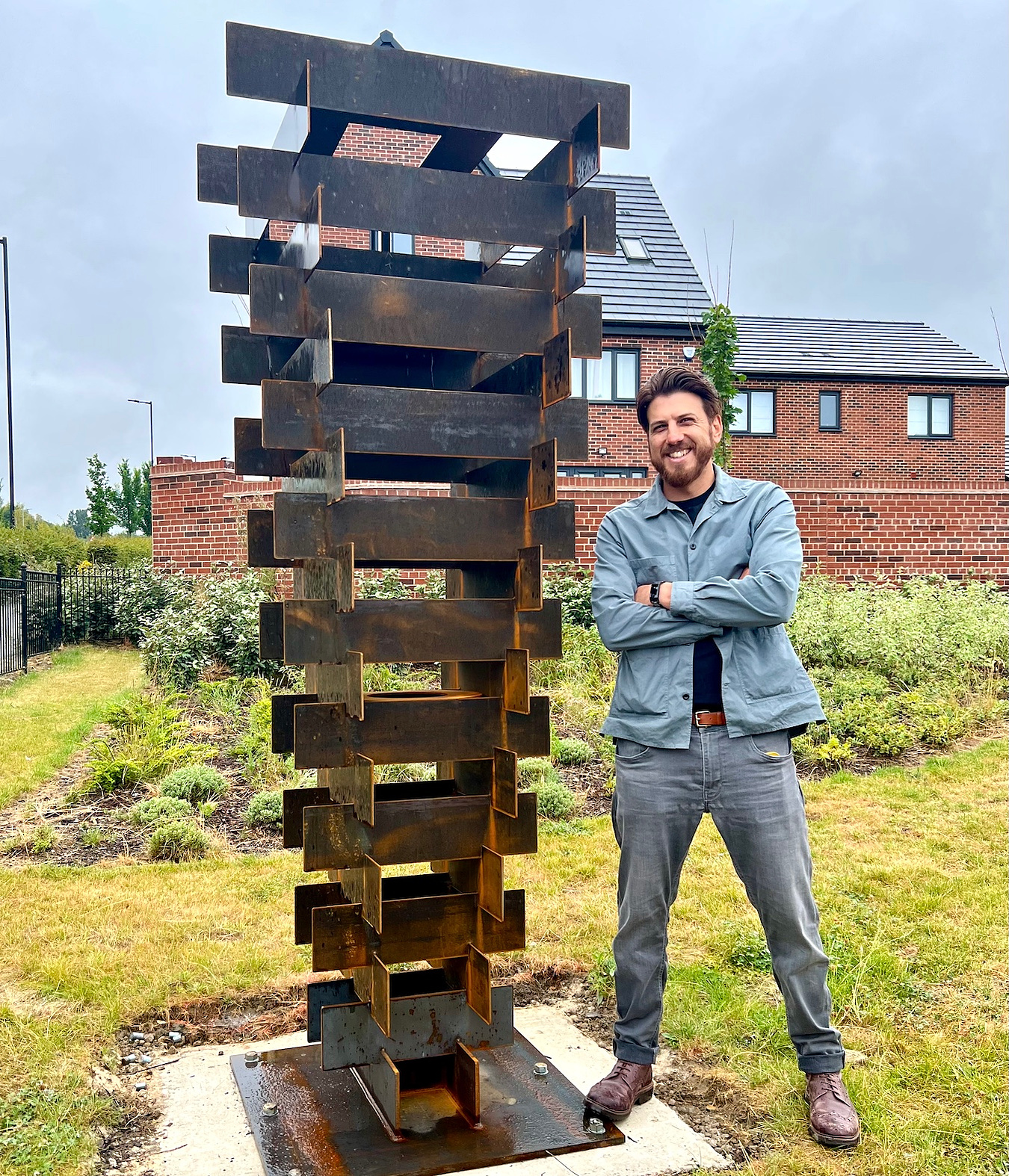 Sapien stood next to his tall Corten Steel sculpture 