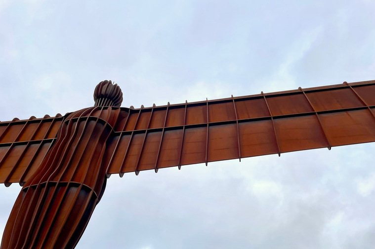 Angel of the North Sculpture by Anthony Gormley. Monumental Corten Steel Sculpture with moody sky behind.