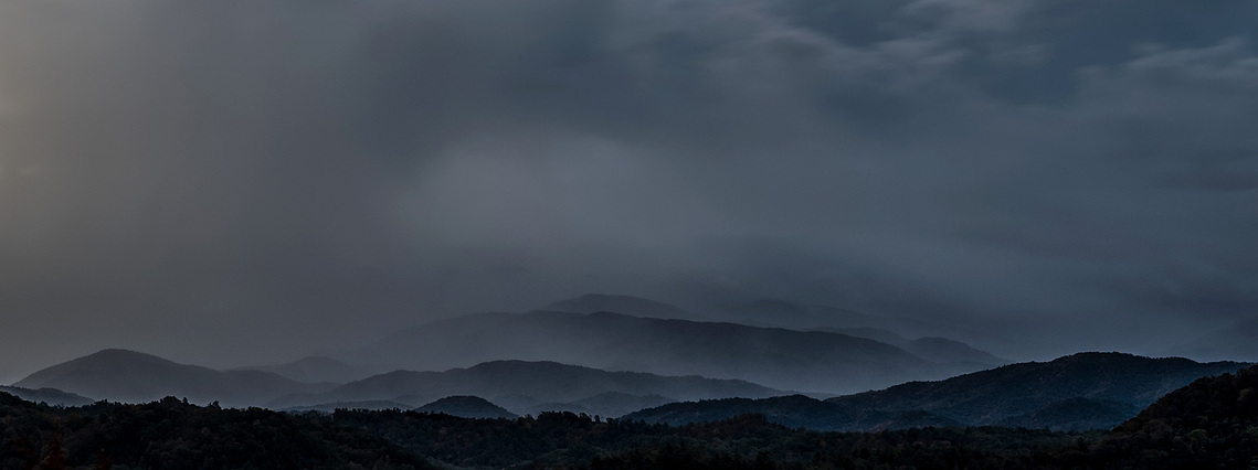 Soft layers of misty fog drift between the ridges of the Great Smoky Mountains National Park, creating a moody blue panorama that captures the park’s namesake atmosphere just before dawn.