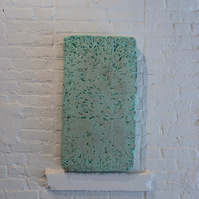 From Priscilla Stadler's SLUDGE art project about Newtown Creek, a toxic waterway dividing Queens & Brooklyn, NYC. Image shows a piece of light green construction foam with many dented markings, which was found at the Creek.