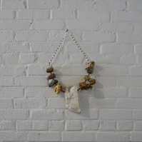 Works from Priscilla Stadler's art project SLUDGE created in response to  toxic Newtown Creek,  NYC, include pieces made with debris found at the Creek. This necklace is made from weathered styrofoam, some of which looks like stones, and beads.