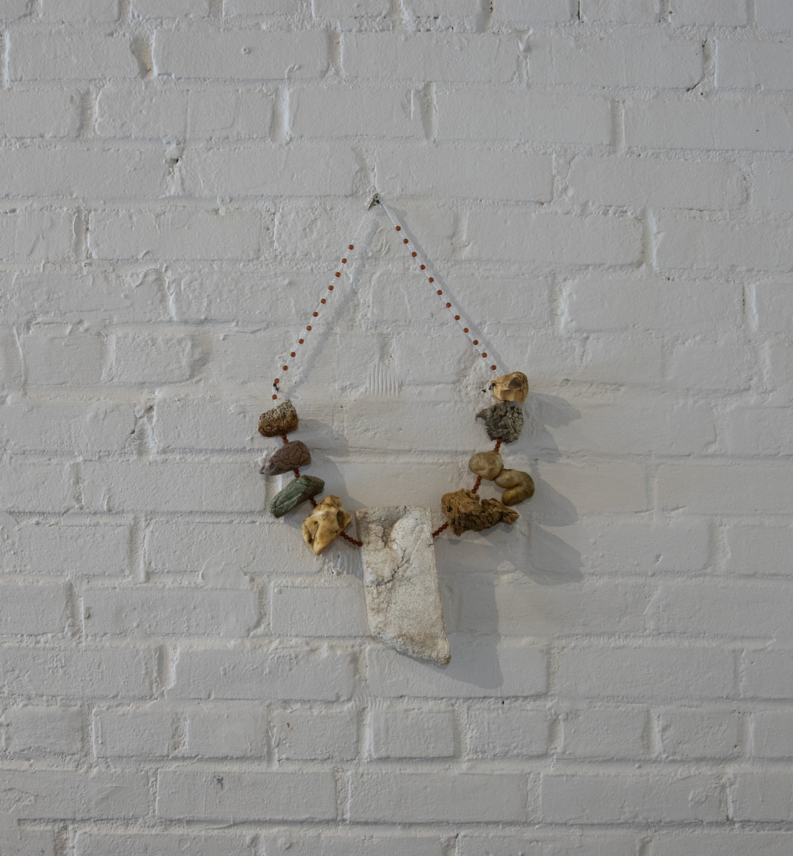 Works from Priscilla Stadler's art project SLUDGE created in response to  toxic Newtown Creek,  NYC, include pieces made with debris found at the Creek. This necklace is made from weathered styrofoam, some of which looks like stones, and beads.