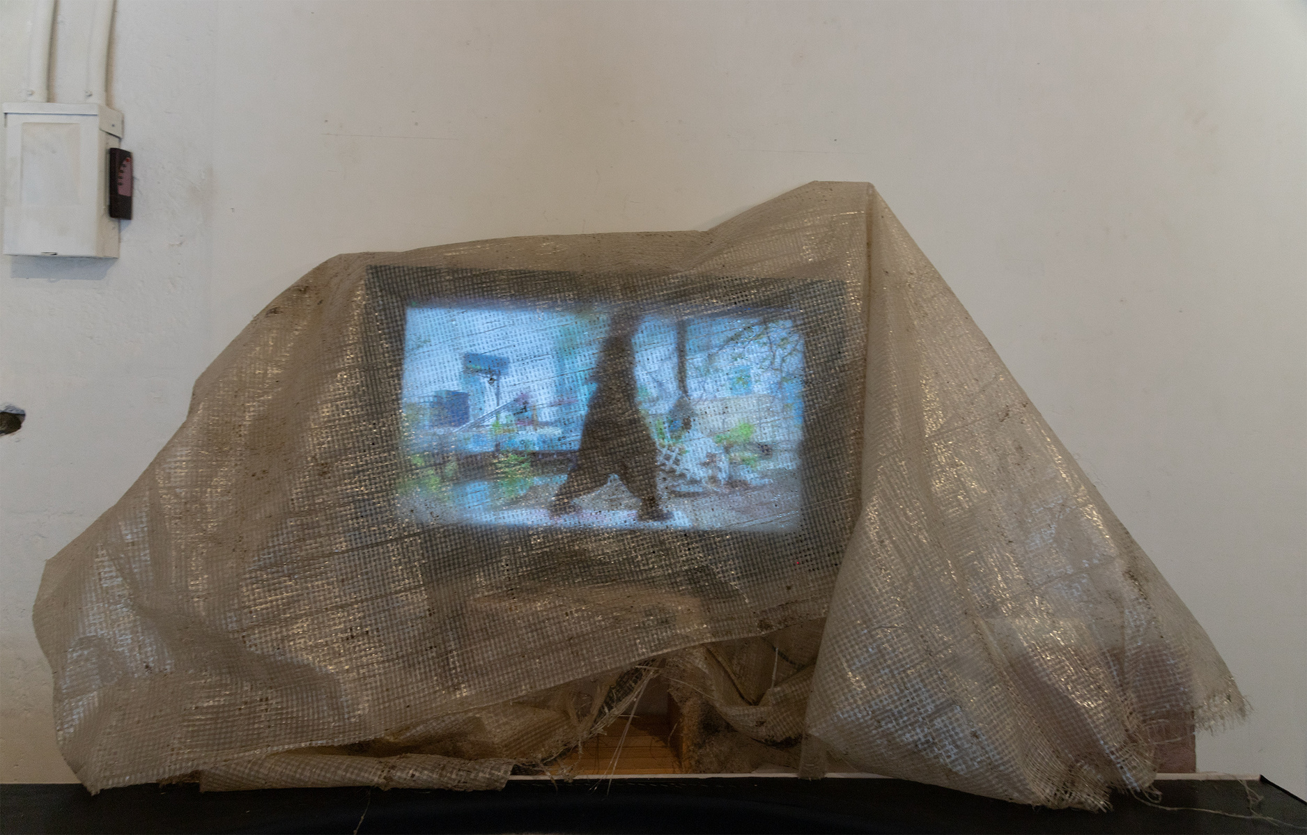 Works from Priscilla Stadler's art project SLUDGE created in response to  toxic Newtown Creek,  NYC, include the video "heal", featuring choreographer/dancer Chris Bisram. Monitor with video draped in weathered cloth found at the Creek.