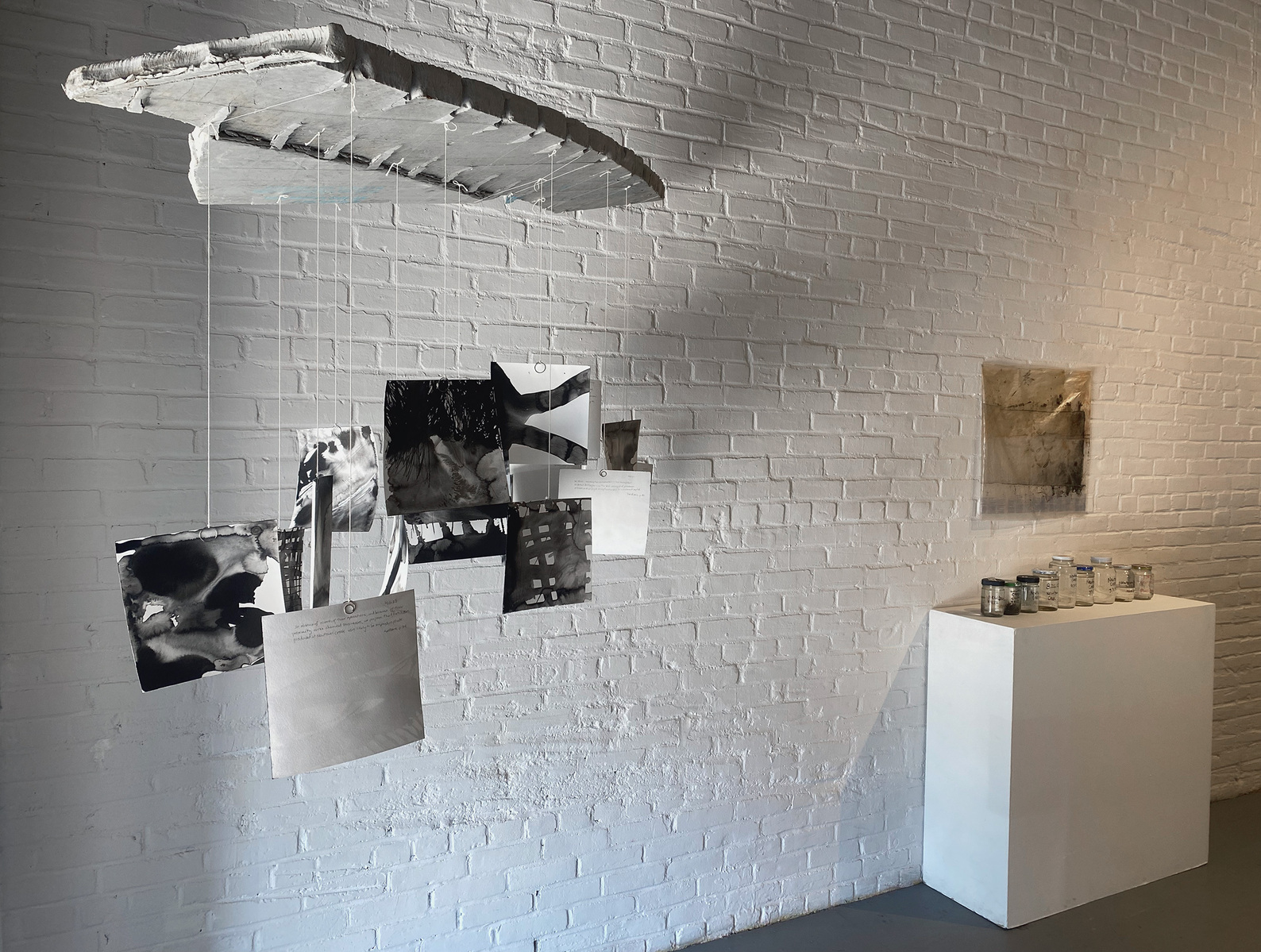 Works from Priscilla Stadler's SLUDGE project, an art installation created in response to researching Newtown Creek, a toxic waterway dividing Queens & Brooklyn, NYC. Left: a sculpture called "Readings"; right: "Troubled Waters 11" (on wall) and "Samples"