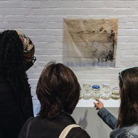 Visitors look at "Samples" and "Troubled Waters 11", works from Priscilla Stadler's SLUDGE project, an art installation created in response to researching Newtown Creek, a toxic waterway dividing Queens & Brooklyn, NYC.
