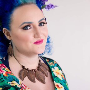 Woman with floral dress, leaf necklace, and blue hair