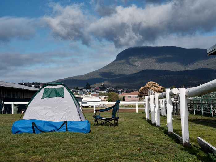 Single person tent neatly pitched at the Hobart Showgrounds with a back drop of Mount Wellington kunanyi.