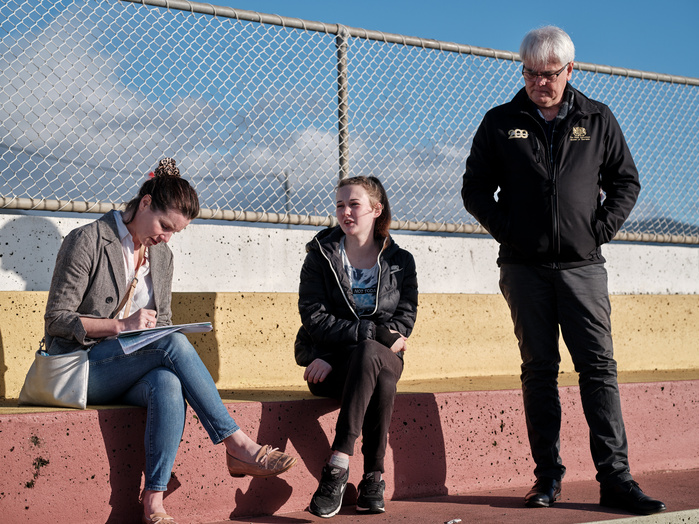 Guardian journalist Philippa Duncan sitting in the sun at the Hobart Showgrounds interviewing Hanna and Scott Gadd.