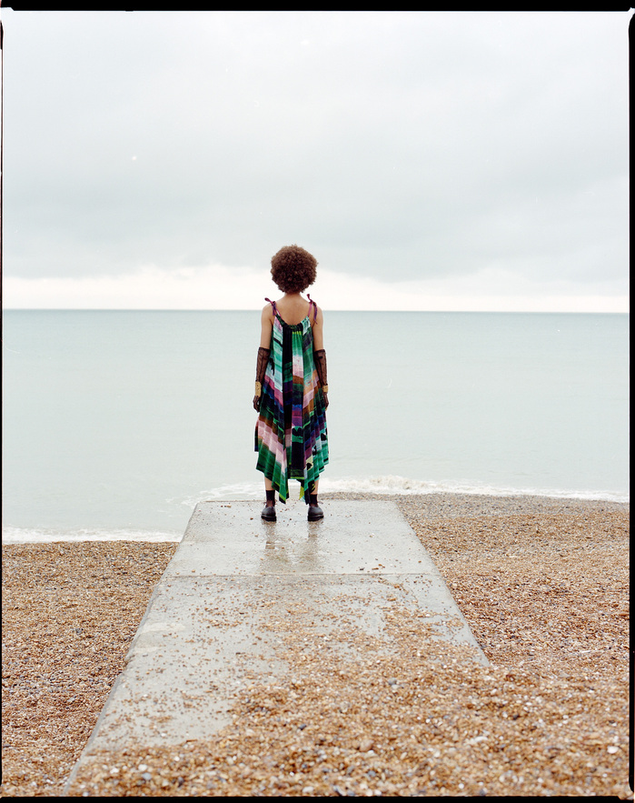 Scarlett Landy pictured by the sea in Hastings in a ISSEY MIYAKE dress