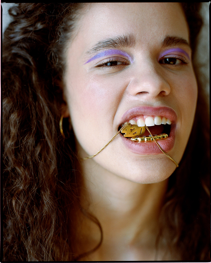 Close-up of Anna Oloyede with 420 jewellery between her teeth