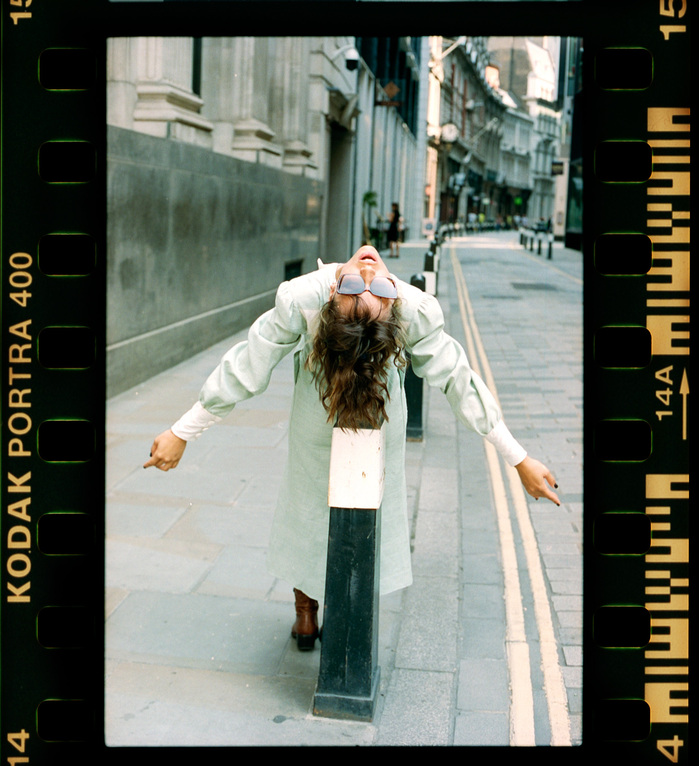 Larissa Diniz hanging off bollard in City of London