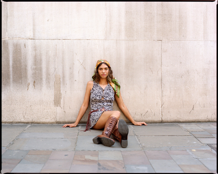 Wide shot Larissa Diniz in sat on pavement in Lothbury in City of London