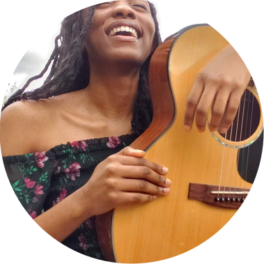 headshot of evan nicole bell (a girl called evan) with an acoustic guitar
