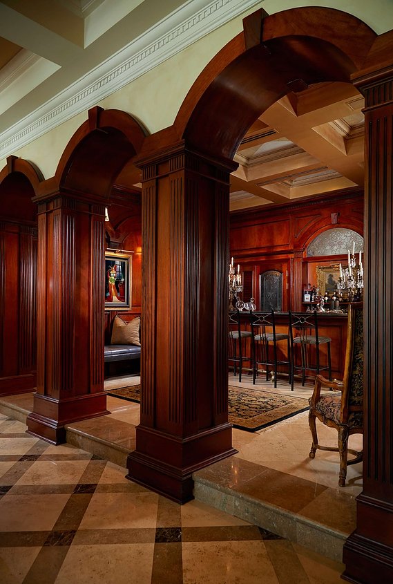 Custom woodwork and ambient lighting set the tone for this distinguished bar, blending sophistication with timeless design.