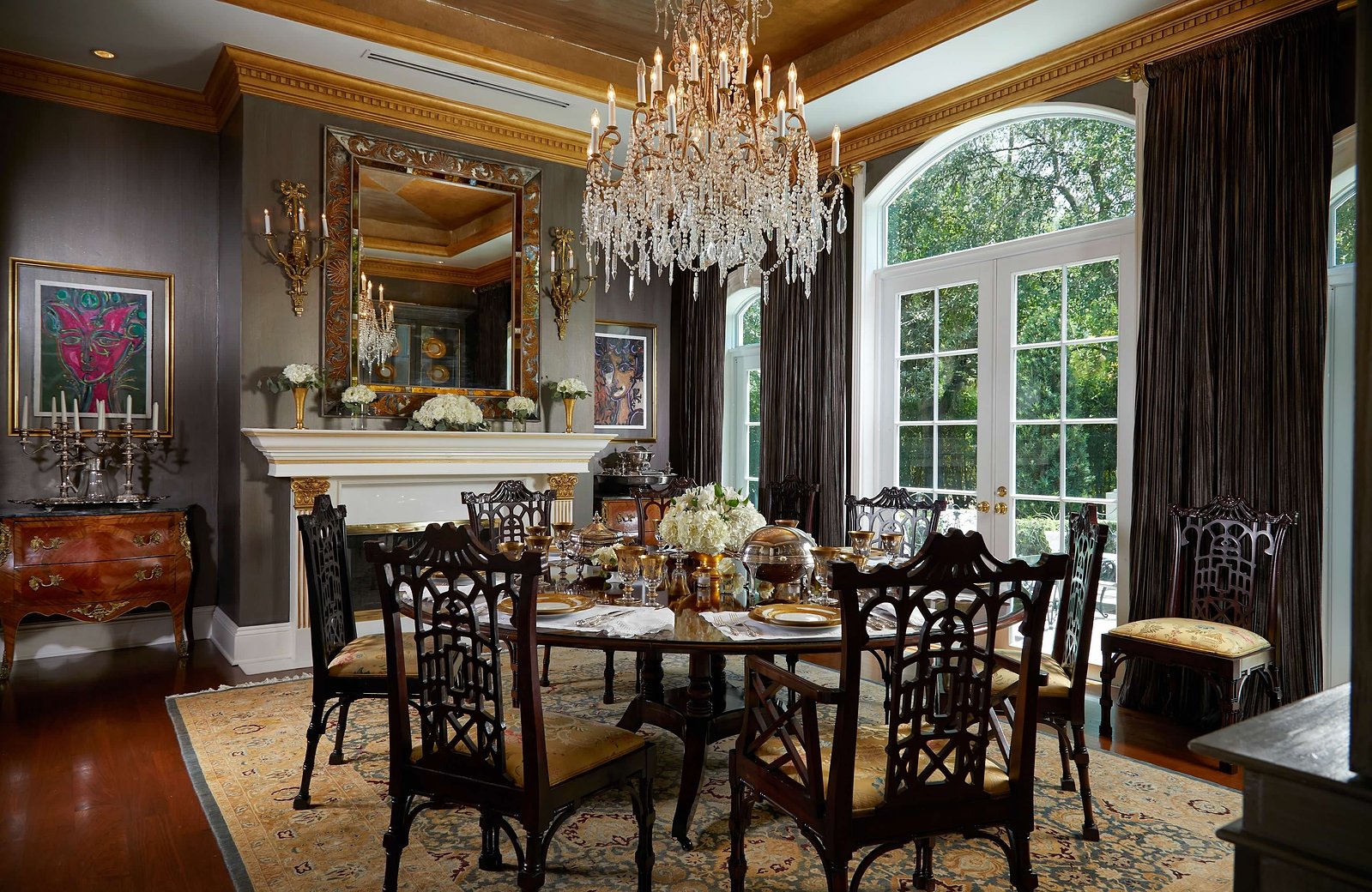 A crystal chandelier, rich wood tones, and classic European details create the ultimate formal dining experience.