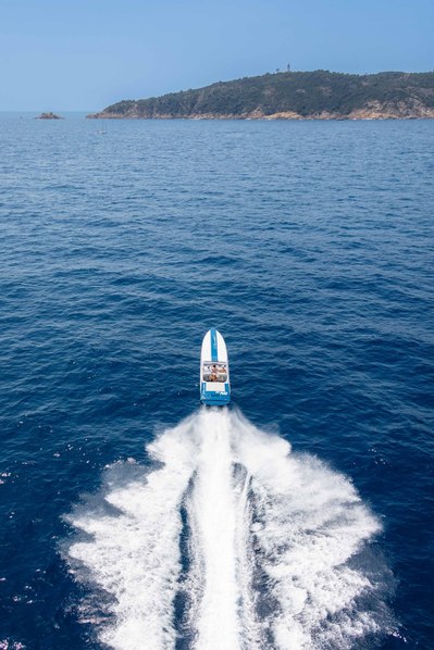 Aerial view from helicopter of a cigarette yacht at high speed in Saint-Tropez, South of France with Cap Camarat in the background.