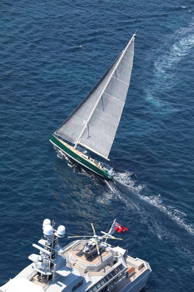 Aerial view from helicopter of a sailing a yacht and a motor yacht with helicopter on the deck in Saint-Tropez, South of France.