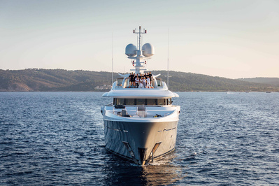 Aerial view from helicopter of a yacht with in front of Pampelonne beach near Saint-Tropez, South of France with all crew standing on the top deck at sunset.