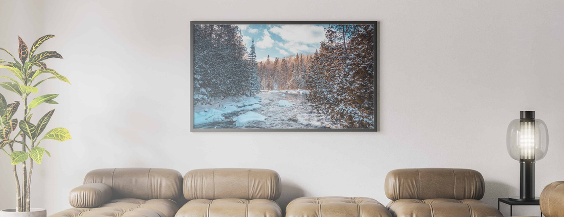 Une photographie de paysages de rivière et de forêt au Canada imprimée et encadrée dans un salon.