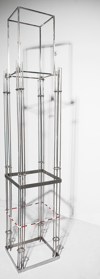 An architectonic cubic cage-like frame sculpture made of stainless steel.