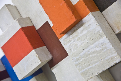 A detail of a architectonic cubic sculpture made of cast concrete and a bit of color
