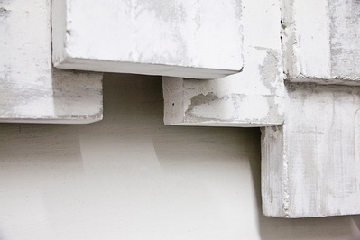 A detail of a architectonic cubic sculpture made of cast concrete with white plaster
