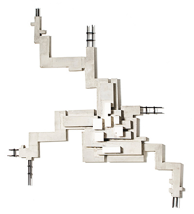 A monochromatic architectonic cubic sculpture made of cast concrete with white plaster that seems to grow organically. Mild steel is part of the construction.