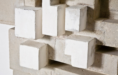 A detail of a architectonic cubic sculpture made of cast concrete with white plaster