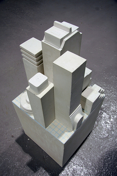 An architectonic cast Carrara marble sculpture. Made of a main cube on the ground and build-like structures that can be moved around on this cube.