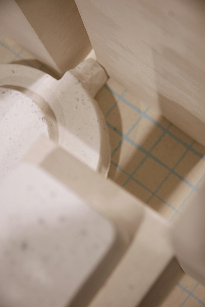 A detail of an architectonic cast Carrara marble sculpture. Made of a main cube on the ground and build-like structures that can be moved around on this cube.