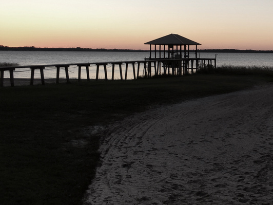 A boat dock in the sunset in the Florida panhandle, highlighting the contrast between foreground and background