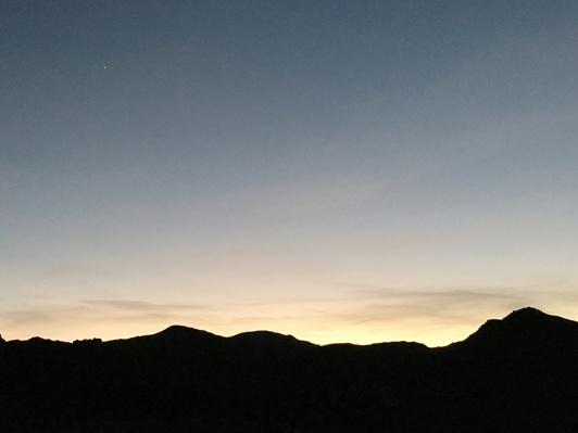 Sunset in Joshua Tree National Park, highlighting gradual contrast between the mountain foreground and sky background