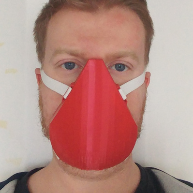Man wearing a red 3D printed face mask that is styled like a respirator mask.